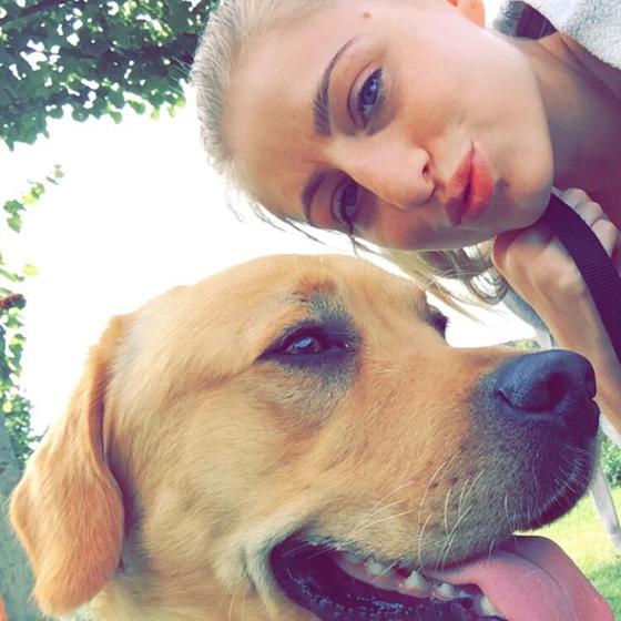 Charlotte cheek to cheek with her golden dog in the park